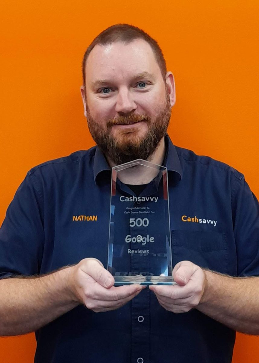 Cash Savvy staff member in a branded shirt holding a 500 Google Reviews award