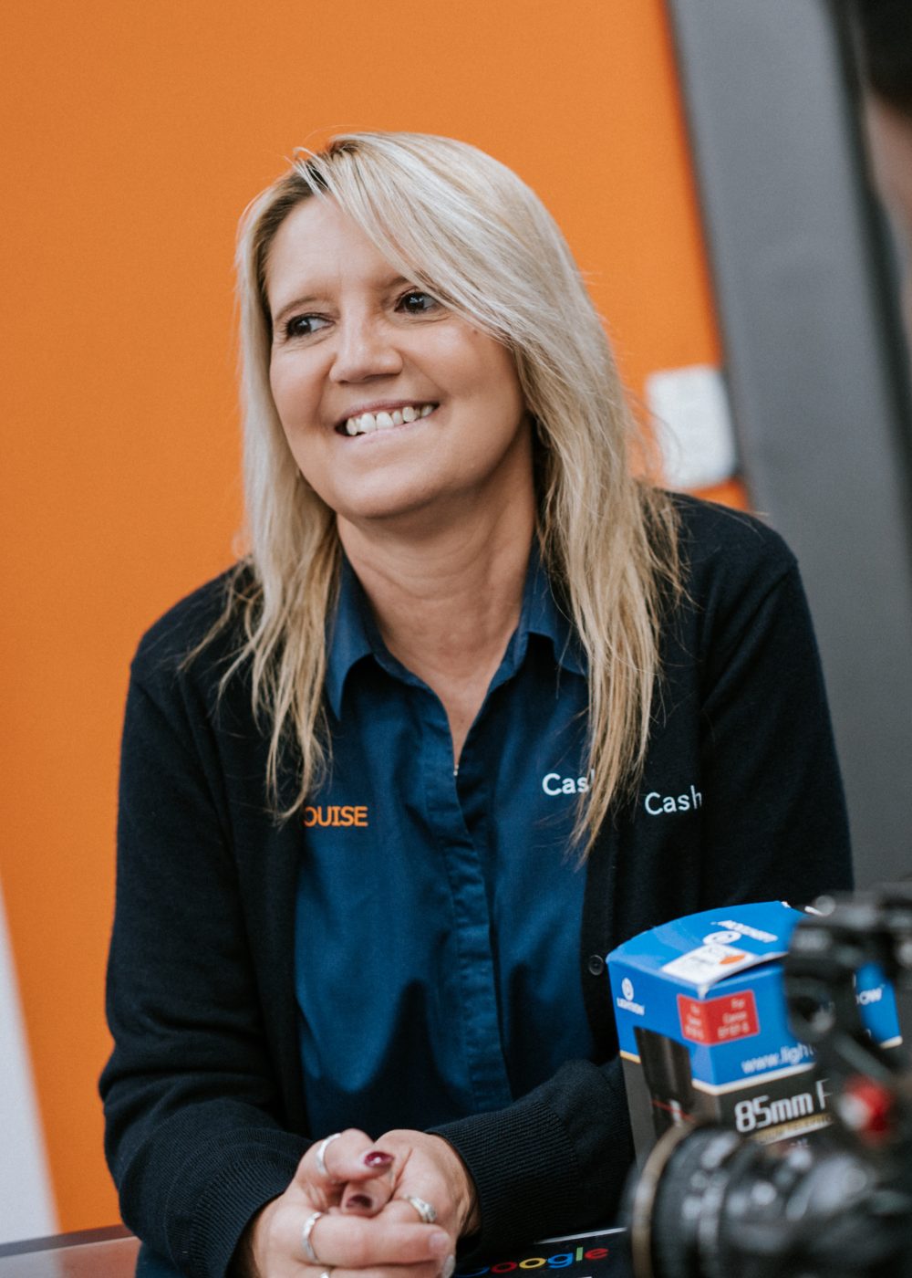 Cash Savvy team member wearing a branded uniform shirt at the service counter