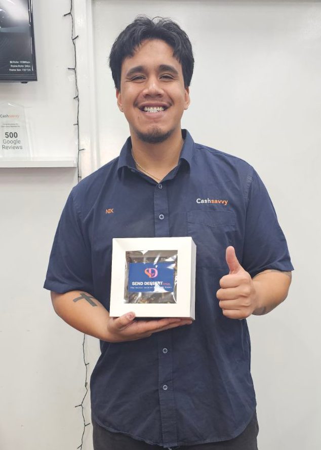 Cash Savvy staff member in a branded shirt holding a gift box