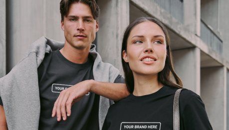 A man and a woman in branded black tees and a hooded sweatshirt