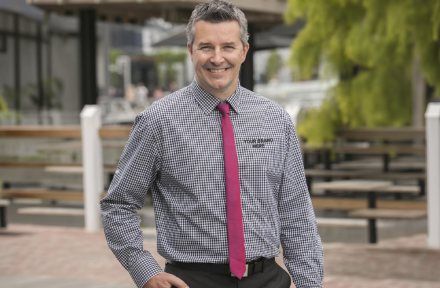 Council staff member in a branded business shirt outside a civic building