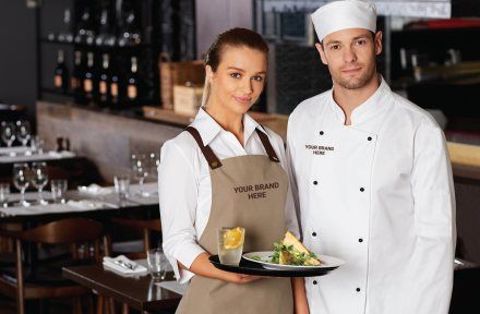 Cafe staff in branded aprons and chef whites serving in a restaurant