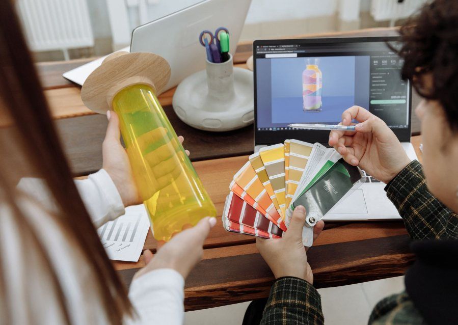 A Payless Promotions designer matching a branded drink bottle to a Pantone colour swatch