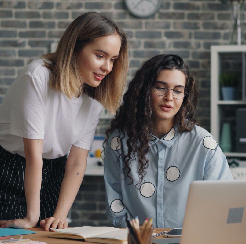 Two Payless Promotions account managers reviewing a client uniform order